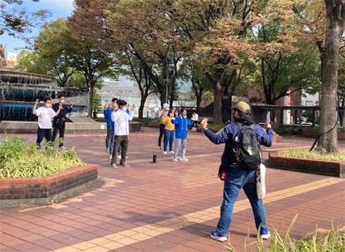 '图3:有的路人看的法轮功学员祥和的炼功场面,模仿学员的动作学练。'