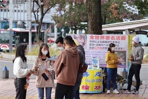 '图4:有不少路人与学员交谈、了解法轮功的真相。'