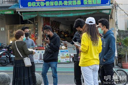 '图8:四位年轻人很高兴接受真相资料,并拿起手机拍下炼功的祥和画面。'