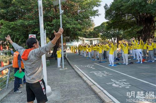 '图11:工程师殷先生因腿伤请休假,顺道来莲池潭看风景,在此巧遇法轮功弘法。他模仿着跟大家炼了一会儿'