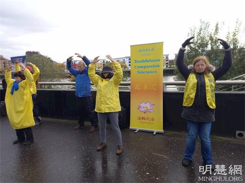 '图1:10月31日 法轮功学员在会场外展示祥和的法轮功功法'