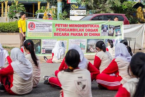 '图12:二零一六年十一月十一日,巴丹岛法轮功学员第二次到Kolese Tiara Bangsa 高职教学生炼法轮功功法。教功后,法轮功学员向Tiara Bangsa 高职学生讲述中共活摘法轮功学员器官的罪行。'