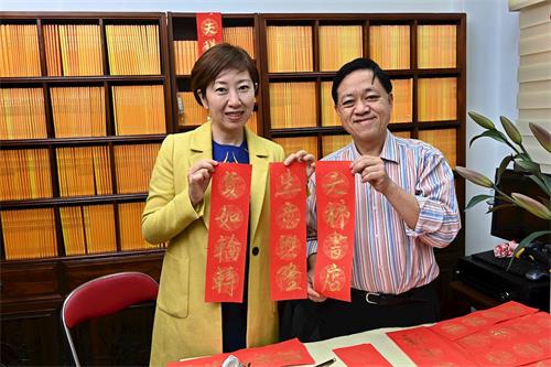 '图2:前区议员林咏然(右)写挥春,恭祝天梯书店生意货如轮转。'