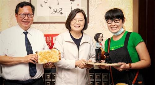 '图7:雷晓臻(右一)致赠创作作品予总统,并与总统(中)及桃园市长郑文灿(左一)一起合影。'