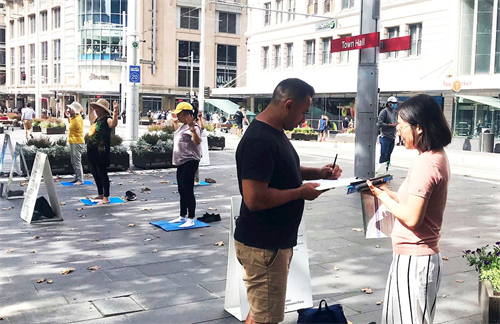 '图2~3:有过往民众了解真相后,在征签表上签名。'
