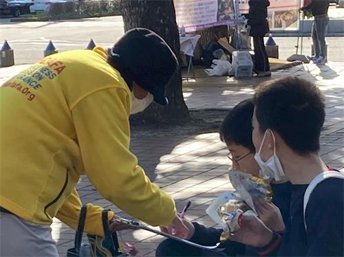 '图6~7:市民在声援诉江的签名纸上签名'