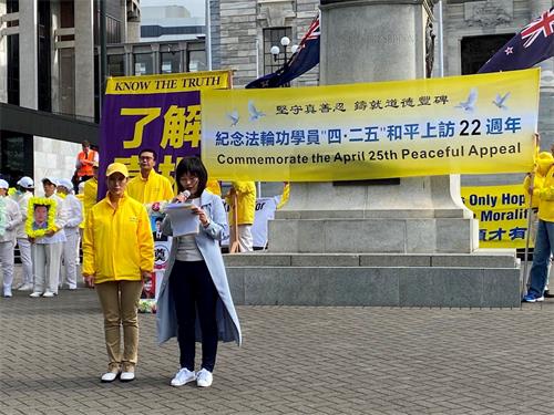 '图12:法轮功学员程静(左)在演讲中'
