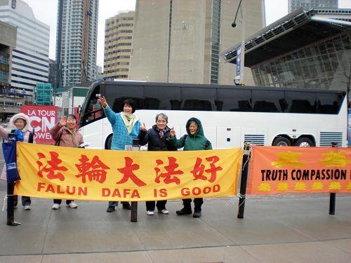 '图6:在多伦多电视塔景点讲真相的王金菊(中间挥手者)跟旅游团的客人挥手告别。'
