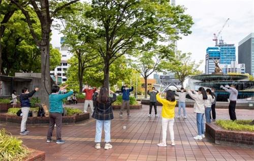 '图1:法轮功学员在日本名古屋市(Nagoya-City)中心的繁华地段炼功,向民众介绍功法。'