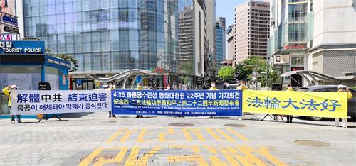 '图1:韩国法轮功学员分别同步在首尔、釜山、光州和济州四处,举办了纪念四・二五和平上访记者会。图为在首尔明洞入口的驻韩中共大使馆前举行记者会的场景。'