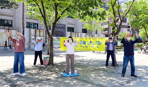 '图5:韩国法轮功学员在驻韩中共大使馆附近集体炼功。'