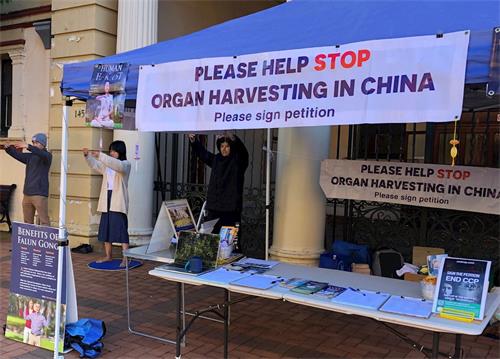 '图1:二零二一年三月二十八日,法轮功学员在阿米代尔大型购物市场展示法轮功五套功法'