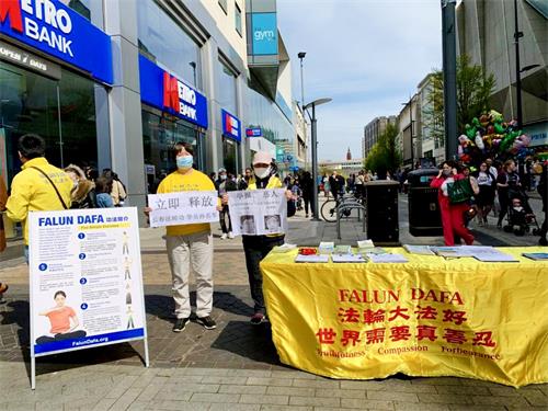图8:2021年4月24日,英国伯明翰(Birmingham)市中心,法轮功学员打出展板“立即释放长春孙长军”、“举报恶人:马延峰、侯淅敏”。