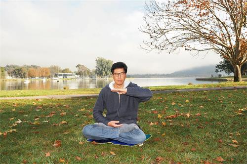 '图3:堪培拉学员李健荣在公园炼法轮功第五套功法——神通加持法。'