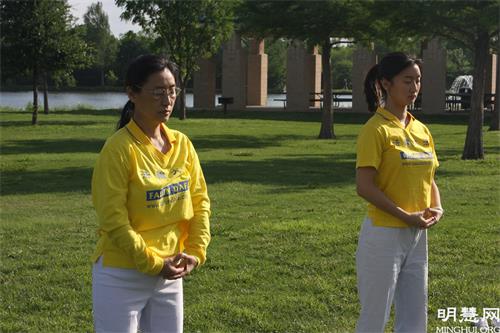图8:法轮功学员张女儿与女儿参加庆祝世界法轮大法日的集体炼功活动。