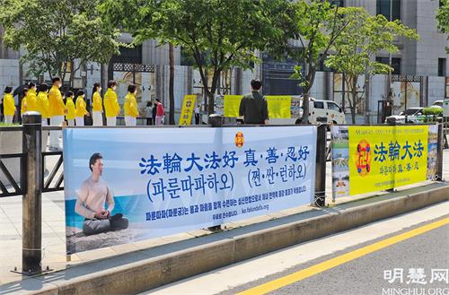 图3:5月13日,部分首尔西部和中部的法轮功学员们在首尔市中心新世界百货店附近举行了集体炼功、派发传单等洪法活动。图为他们在集体炼功的场面。