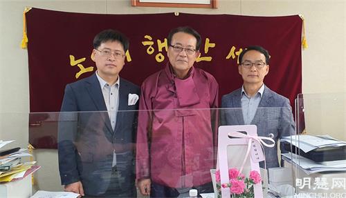 图17:大韩老人会会长金浩日(中)与法轮功学员合影。