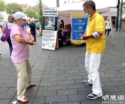 '图5:学员教中年女士法轮功功法。'