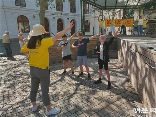 '图6:三个少年跟着法轮功学员学炼第一套功法'