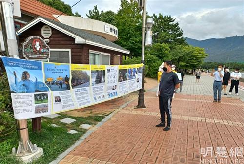'图6:这位男士认真阅读真相横幅上的内容'