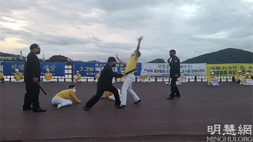 '图7:活动中,学员以真人演示,揭露中共警察迫害法轮功学员。'