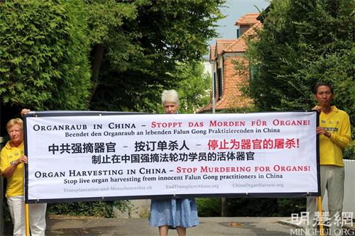 '图1~2: 法轮功学员在中共驻伯尔尼领馆前要求停止迫害并读劝善信。'
