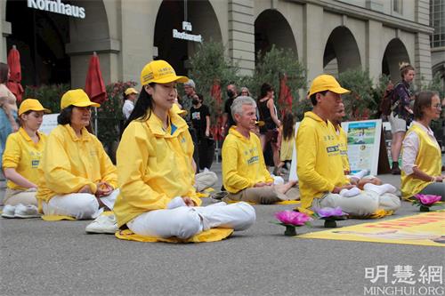 '图3~5:法轮功学员在闹市中功法演示,给人带来一份平静、祥和。'