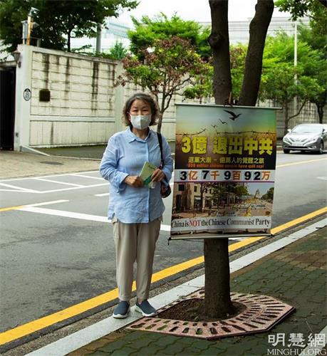'图1:驻釜山中国总领事馆对面,南女士每天在固定的地点挂好真相横幅,向中国人发放真相资料。'