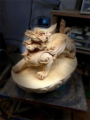 '图3:蔡明峰雕刻《貔貅》,桧木2尺,以及《貔貅》完成品。'