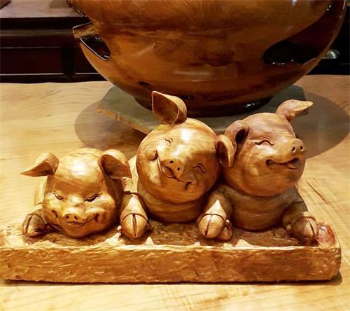 '图4:蔡明峰木雕作品山猪,憨态可爱又可喜。图为作品《童年》:用三只小猪不同的表情来表现小时候无论是兄弟、姐妹、同学邻居、朋友中的玩耍打闹,长大后回忆起来是一种没有恩怨情仇的天真无邪,善良。'