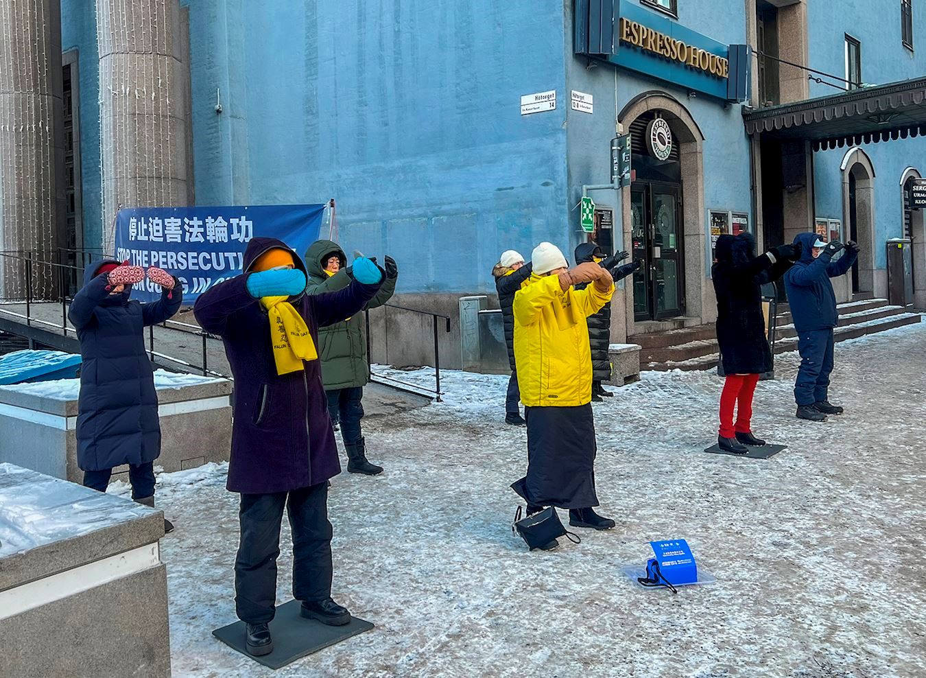 '图1:二零二二年十二月十七日,法轮功学员在斯德哥尔摩音乐厅旁举办讲真相活动。祥和的炼功场面,吸引着过往路人前来了解真相。'