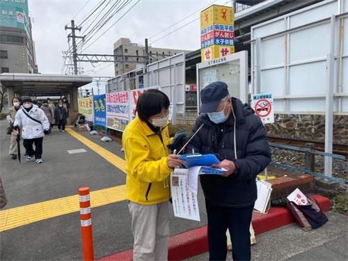 '图2:日本民众在声援诉江签名纸上签名'