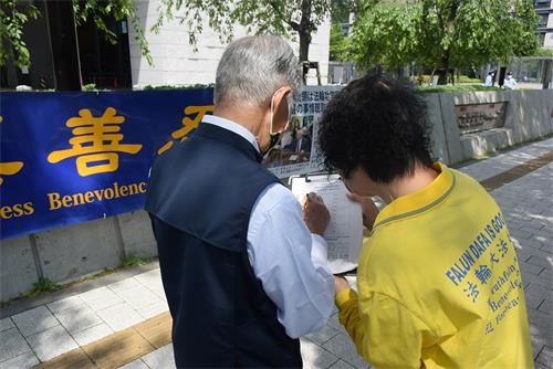 图3:正在签名的金本先生