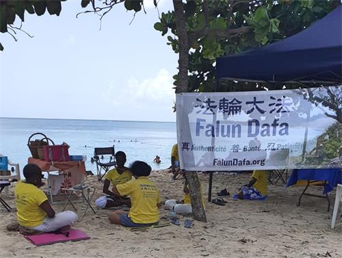 图1:二零二二年七月二十四日,法轮功学员在路易港的苏弗莱尔海滩传播法轮功真相。图中法轮功学员正在炼功。