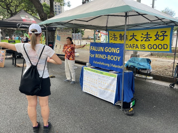 图7:民众主动在展台前学炼法轮功五套功法