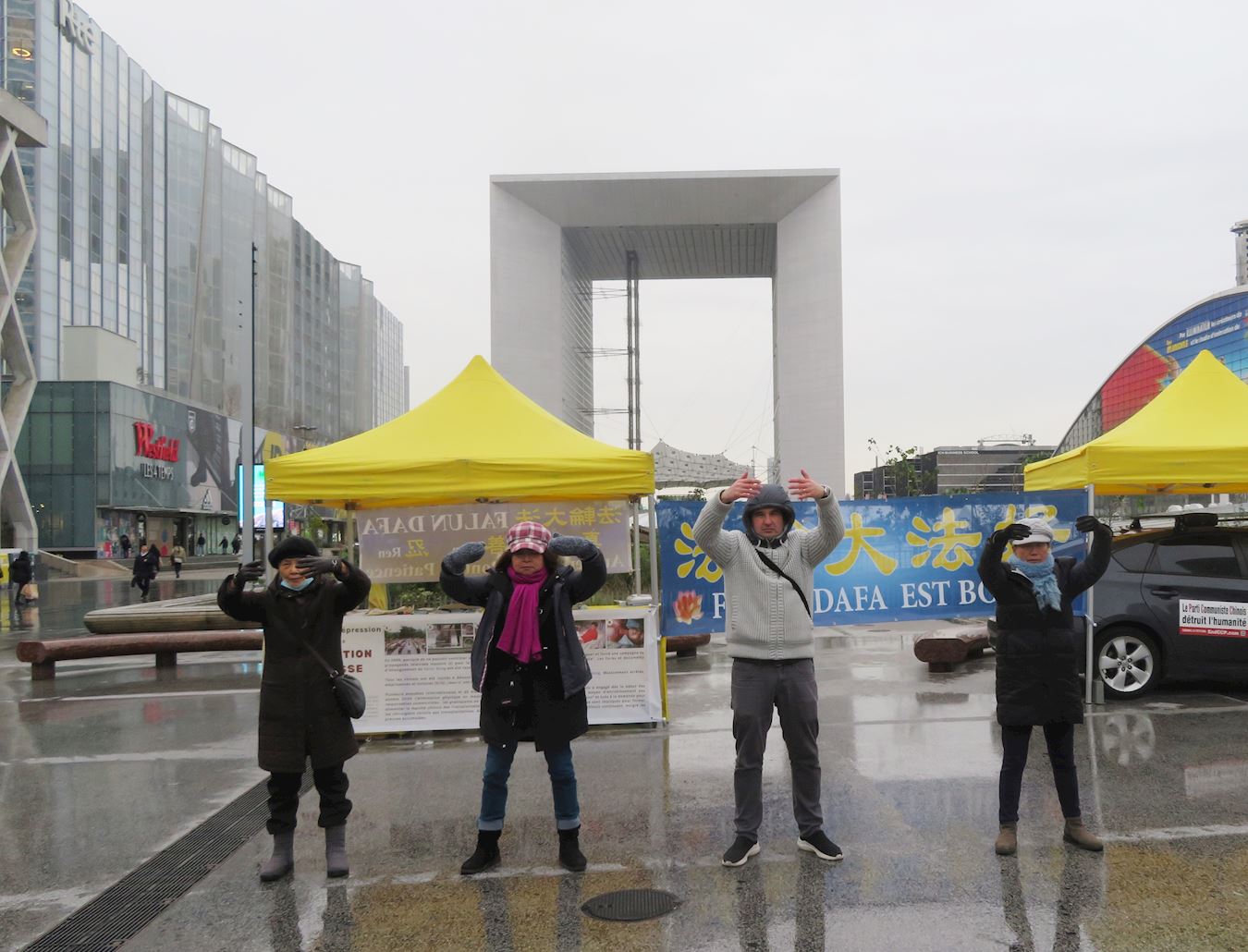 '图1:二零二三年十二月七日,法轮功学员在巴黎拉德芳斯广场进行了讲真相、征集签名反对中共迫害的活动。图为法轮功学员在演示法轮功功法。'