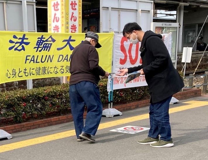 '图1~3:在名铁国府宫的车站附近,法轮功学员在向过往民众发资料,并讲法轮功真相'