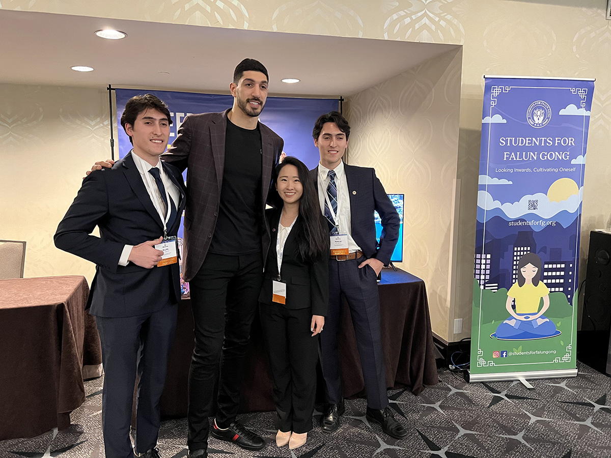 图10:职业篮球运动员埃内斯·坎特·自由(Enes Kanter Freedom,左二)与法轮功展位上的年轻学员合影。