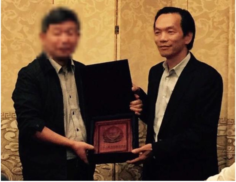 图3:二零一五年习*近*平访美后卢建旺(右)收到中共公安部颁发的一块牌匾。(起诉书截图)