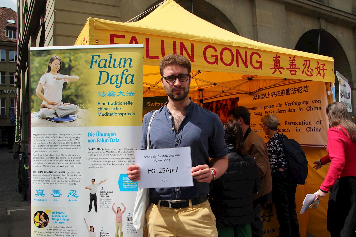 '图1:医生马丁听闻四二五万人上访实况及随之中共二十四年来的迫害真相后,当下询问该如何支持法轮功学员,并同意举牌留影帮助传播真相'