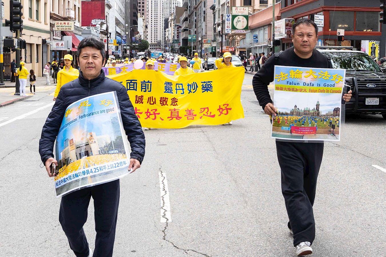 '图27:逃离中共统治的高先生和郝先生手持“法轮大法好”和“真善忍好”海报参加游行'