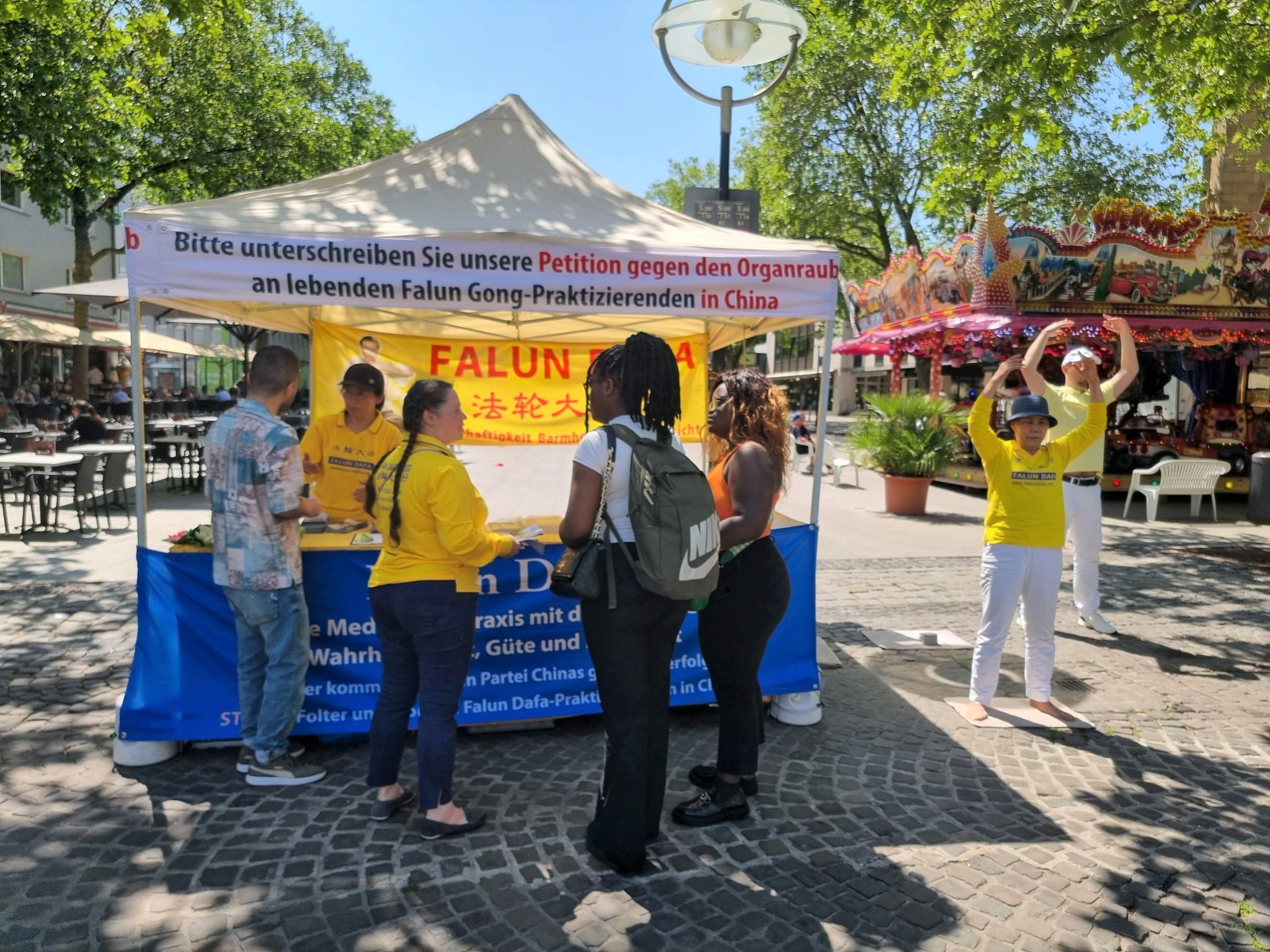 图1:法轮功学员在多特蒙德(Dortmund)真相点炼功、讲真相。