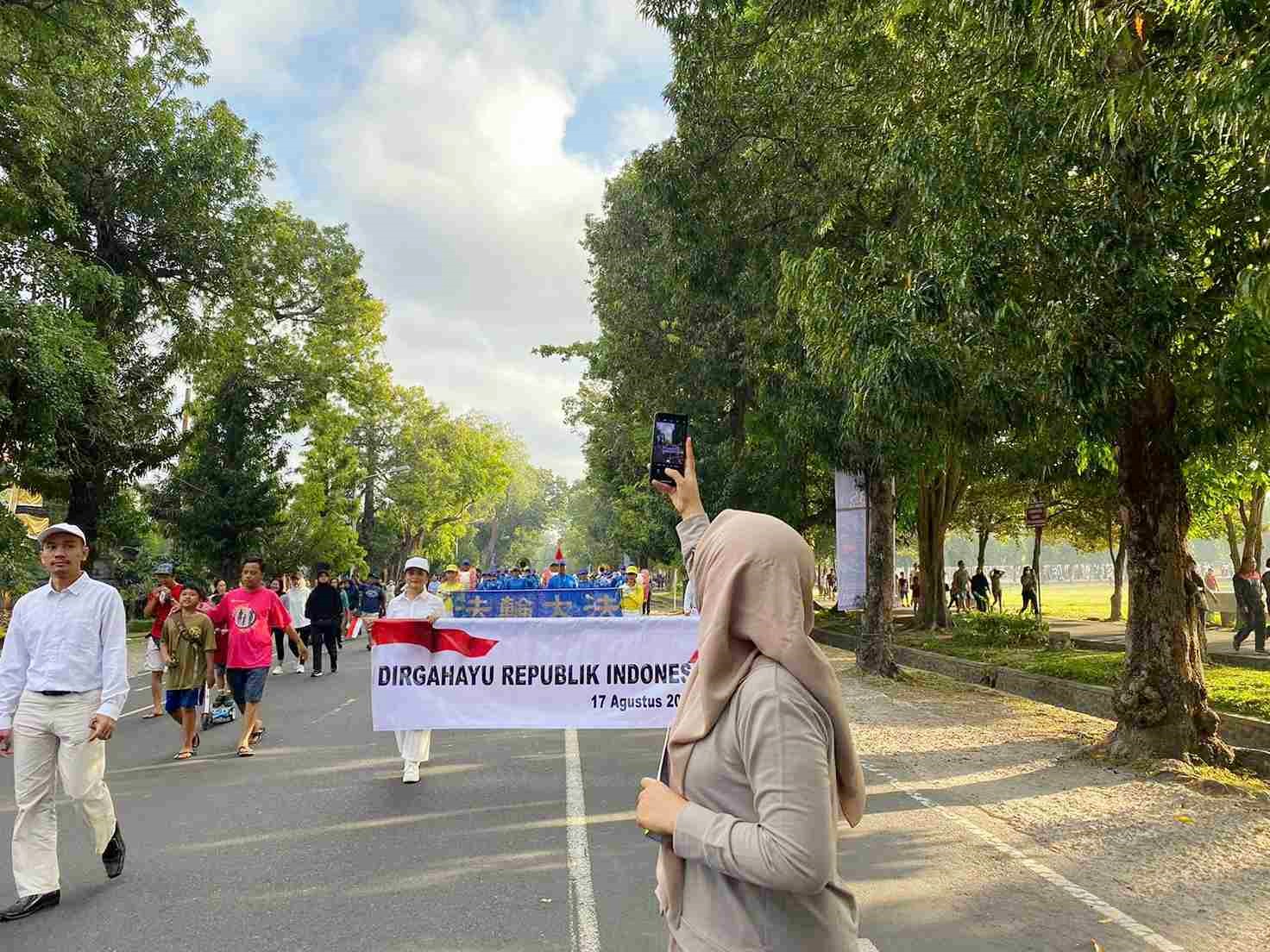 图2:观众纷纷为法轮功学员的游行拍照和录像。