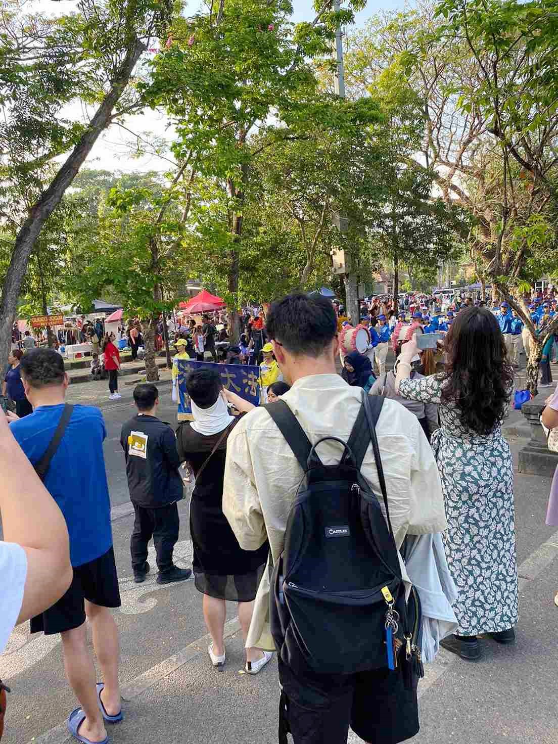 图3:来自中国大陆的游客拍摄法轮功学员游行的盛况。