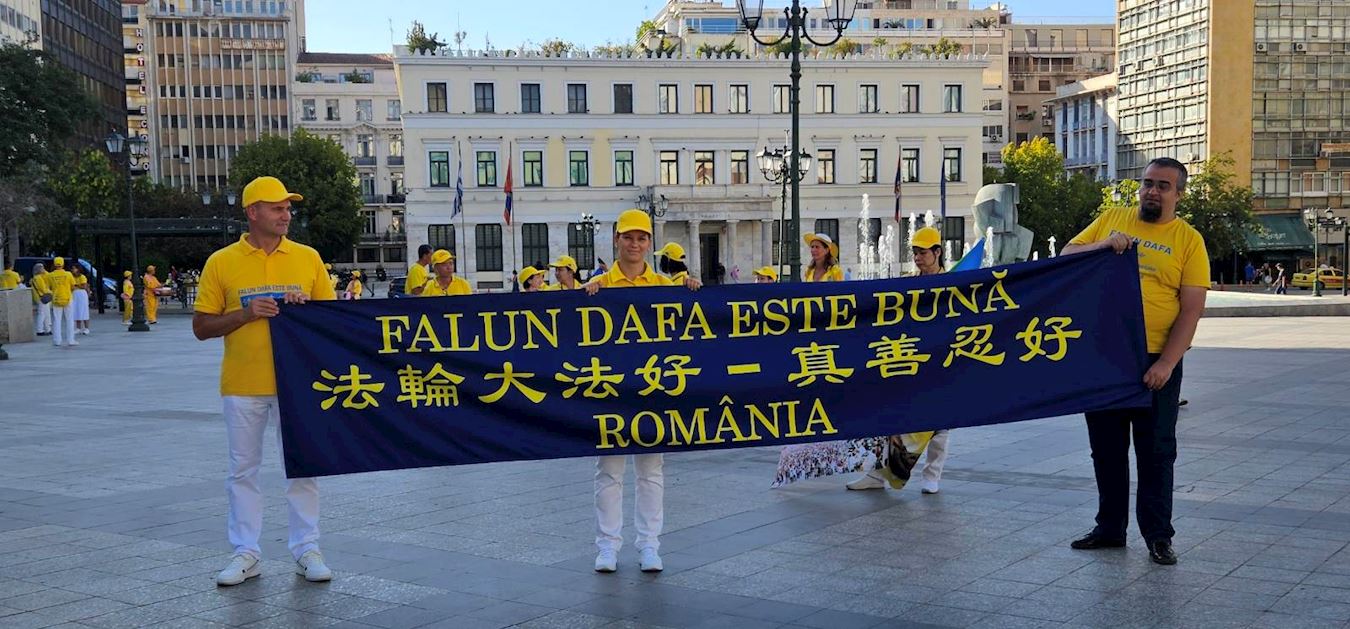 '图2:罗马尼亚学员在雅典科齐亚广场参加游行活动,手持代表他们国家的横幅'
