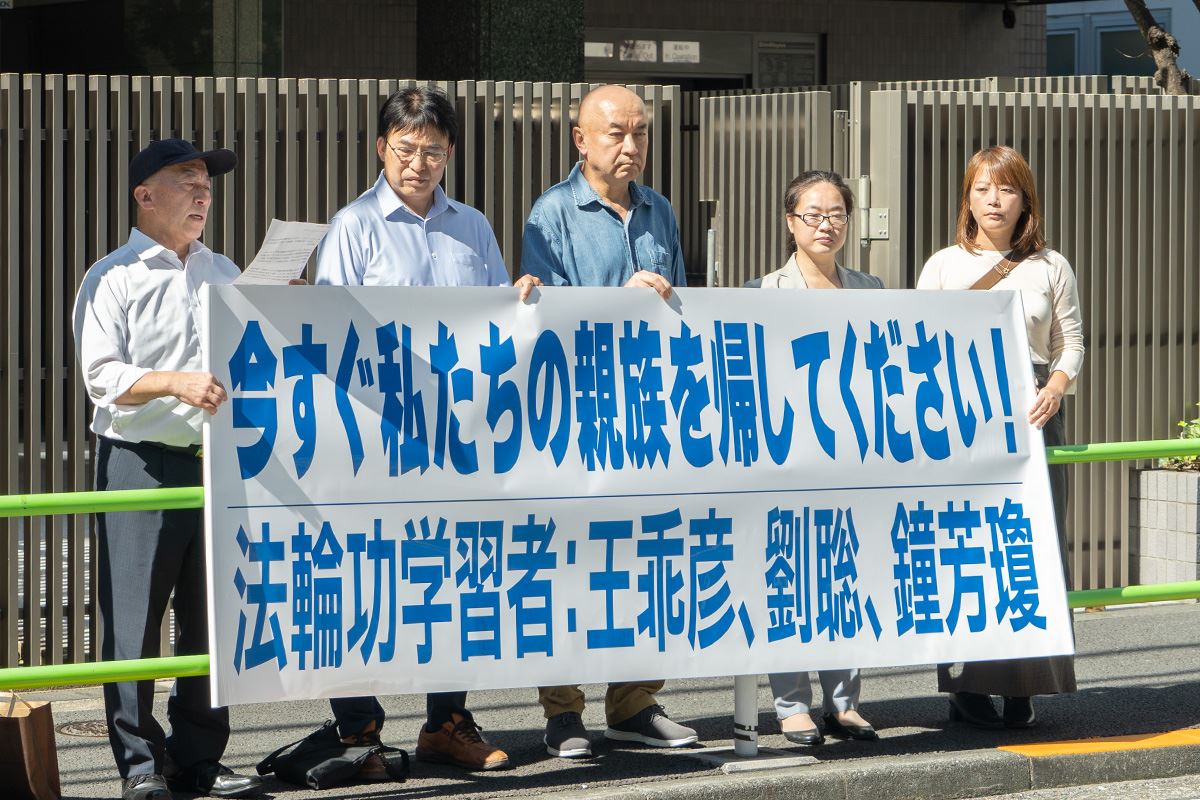 '图1:二零二四年十月十二日,逗子市议员丸山治章(左二)、安华托蒂先生(中)、张述慧女士和刘希月女士在中国大使馆前宣读抗议信。'