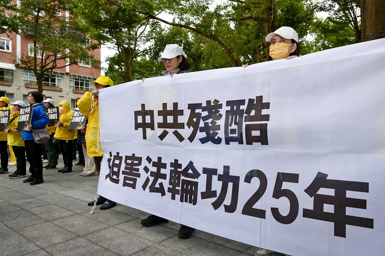 '图1~2:十二月十六日,台湾部份法轮功学员齐聚在晶华酒店外,向上海官员车队展示“法轮大法好”“停止迫害法轮功”“中共残酷迫害对法轮功25年”等大型横幅,表达要求。'