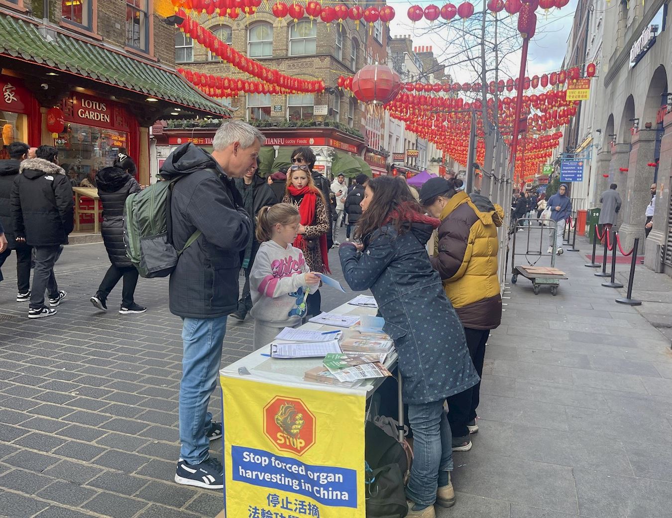 '图1:二零二四年二月二十四日元宵佳节,法轮功学员在英国伦敦唐人街弘法讲真相传福音,吸引人们驻足观看,有的主动与学员交谈,询问更多关于法轮功的讯息。'