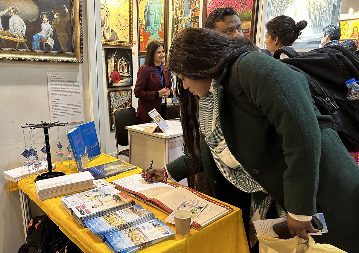 图13~14:参观法轮大法学员展位的访客可以在展位的留言簿上留下他们对美展的感受。