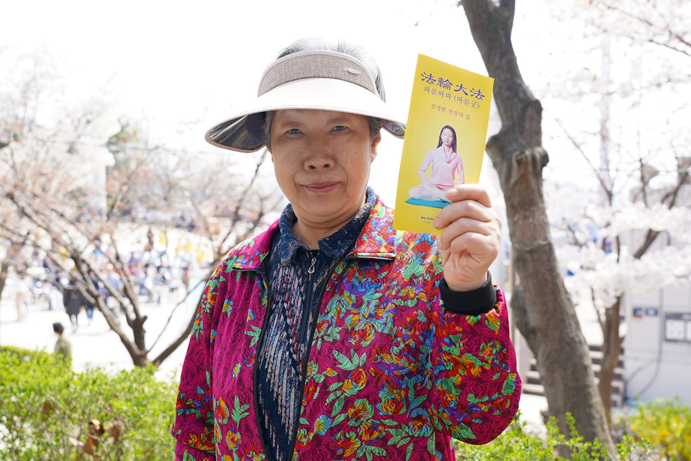 '图5:市民李玉惠(Lee Okhui)手拿法轮功的真相传单'